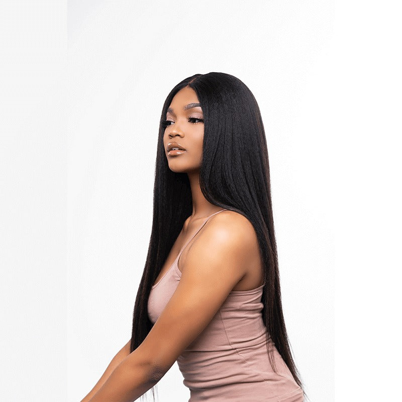 A woman with kinky straight black hair, wearing a beige top, showcasing the hair extension.